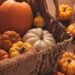 pumpkins in a basket in warm autumn colors, cozy fall scene for frugal habits and money saving-ideas