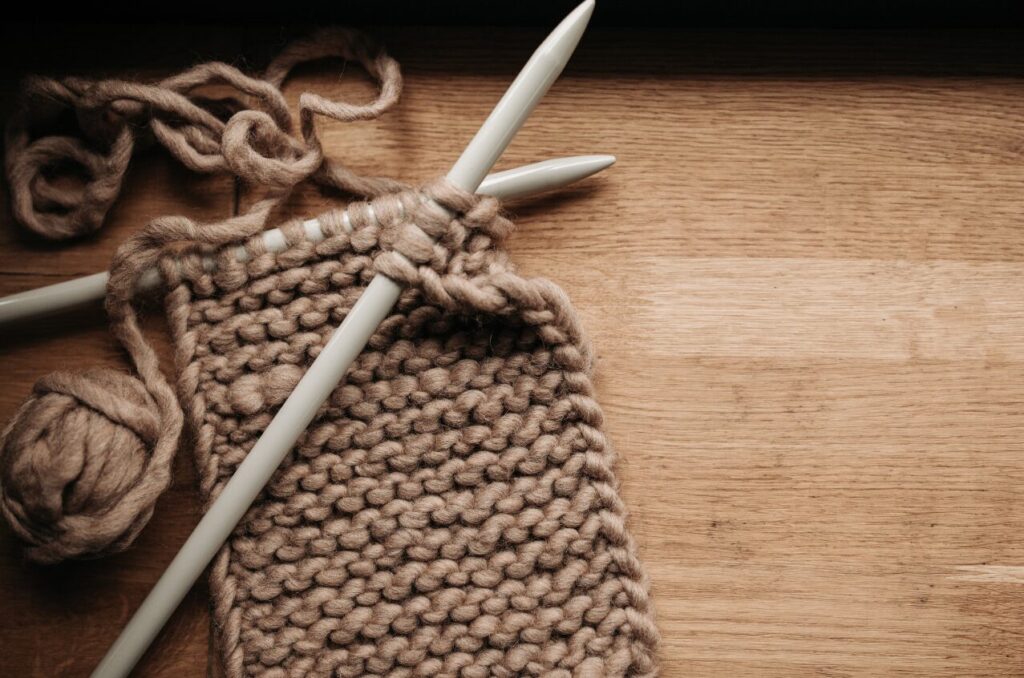 knitting brown yarn and knitting needles - a cheap hobby you can do at home