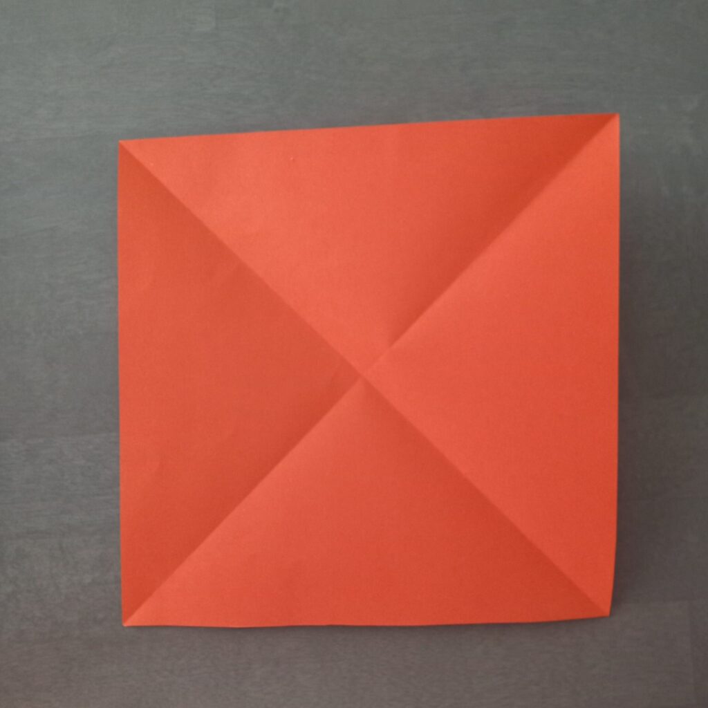 DIY Halloween lantern step 1 Step 1: Folding square paper diagonally to form triangle base for origami lantern.