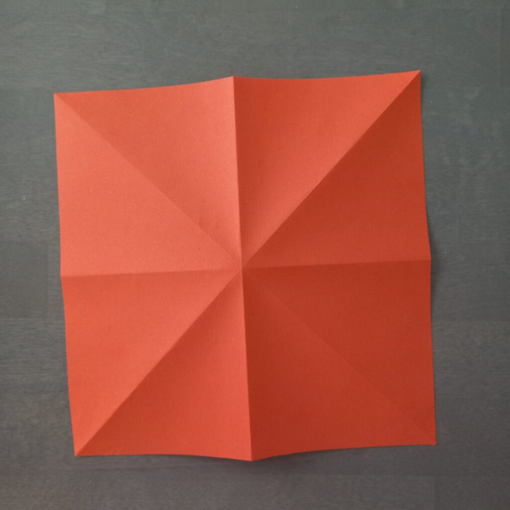 DIY Halloween lantern step 2 Step 2: Folding paper in half horizontally and vertically for origami string light lantern.