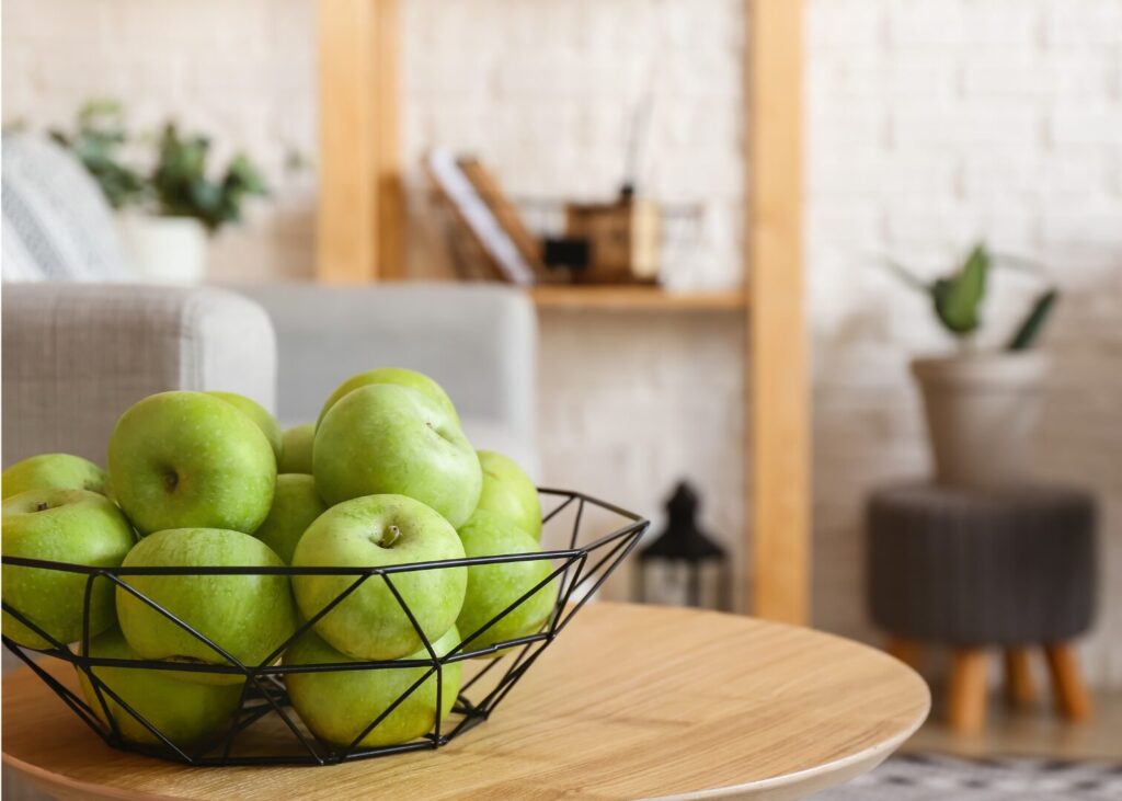 bowl of green apples on a coffee table as a frugal autumn decoration