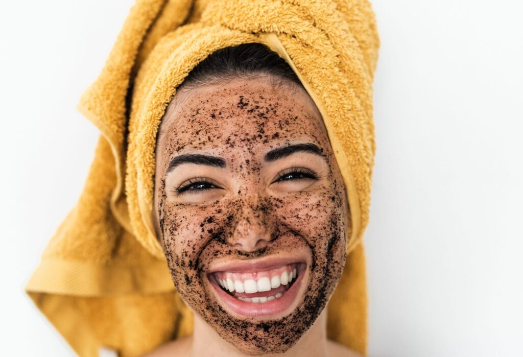 A woman wearing a homemade coffee face mask as part of a natural, budget-friendly skincare routine.